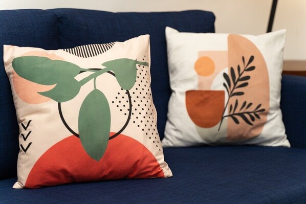 Two pillows with abstract designs on a blue sofa. - Tower Condo Pretty Ocean View Boca Chica (Boca Chica)
