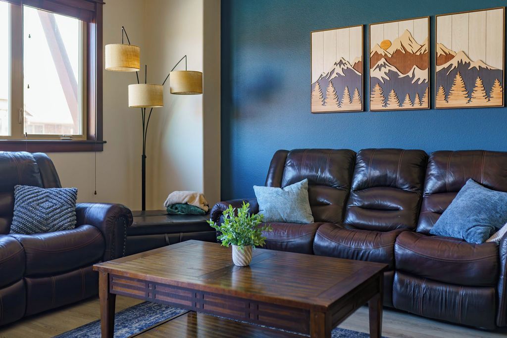 A living room with a brown leather sofa, a wooden coffee table, and a floor lamp.