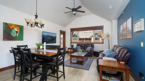 A spacious living area with a dining table, chairs, a sofa, and a ceiling fan. - Stylish, fully equipped 2-bed / 2-bath condo in Riverstone Village (Coeur d'Alene)