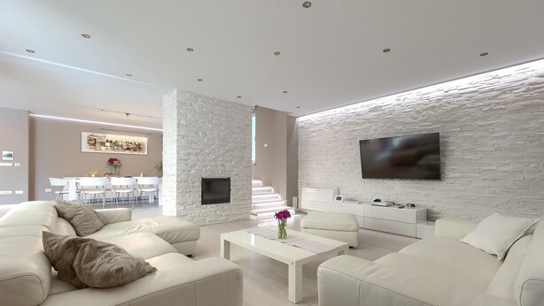 A modern living room with a white stone wall, a flat-screen TV, and a dining area in the background. - Amazing home in Porec (Porec)