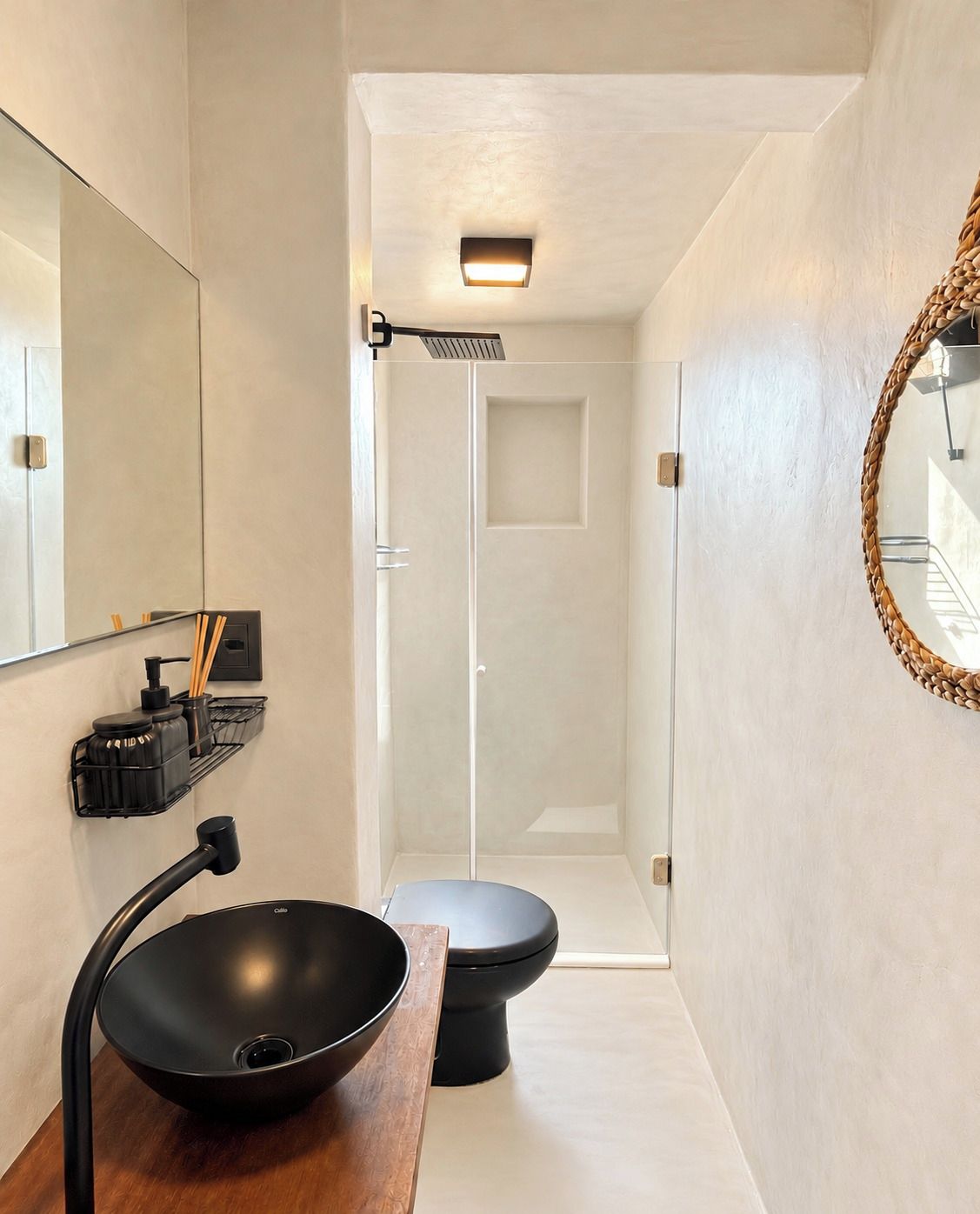 Une salle de bain moderne avec un lavabo, des toilettes et une douche, le tout de couleur noire.