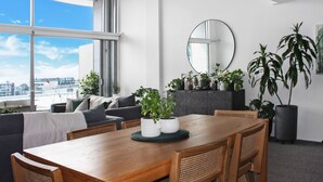 Un espace repas moderne avec une table en bois, des chaises et des plantes en pot.