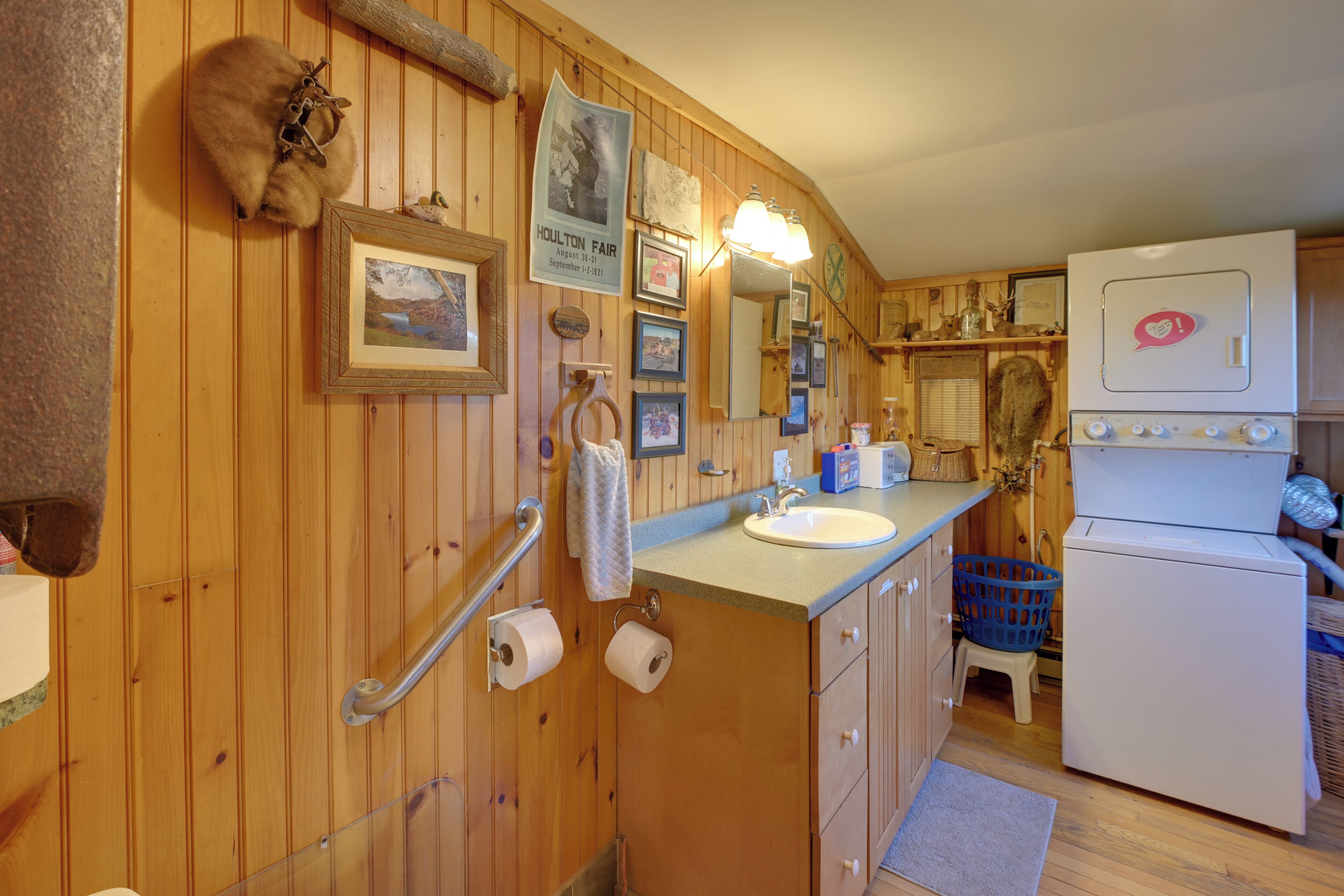L’intérieur d’une cabane en bois comprend une salle de bain, un lavabo, un miroir, des toilettes et un réfrigérateur.