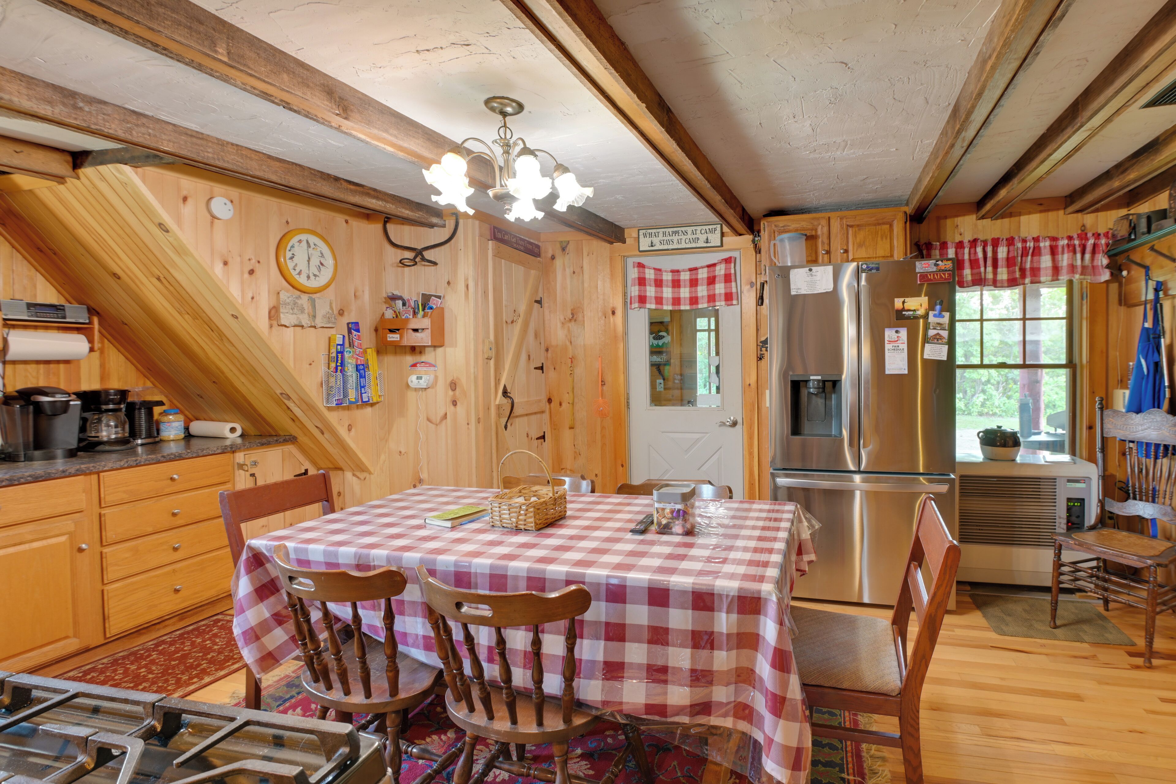 L’intérieur d’une cabane comprend une cuisine, un coin repas et un plafond en bois.