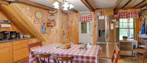 L’intérieur d’une cabane comprend une cuisine, un coin repas et un plafond en bois.