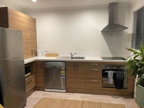 Fridge, microwave, oven, stovetop - Two-bedroom new-build house in Hamilton's central area. (Hamilton)
