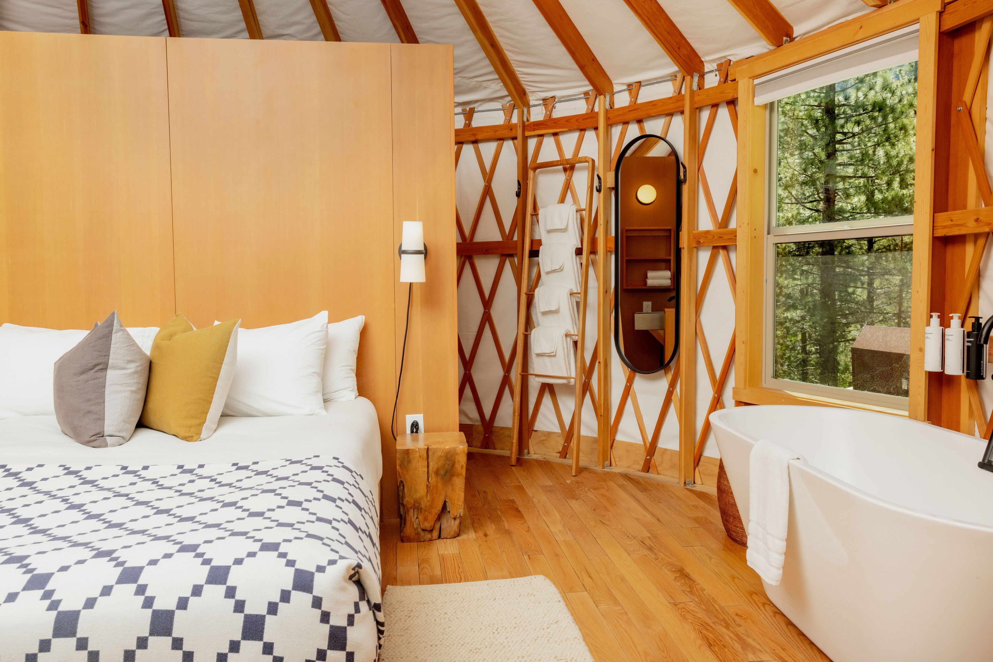 Une chambre à coucher avec un lit, un mur en bois, une fenêtre et une baignoire.