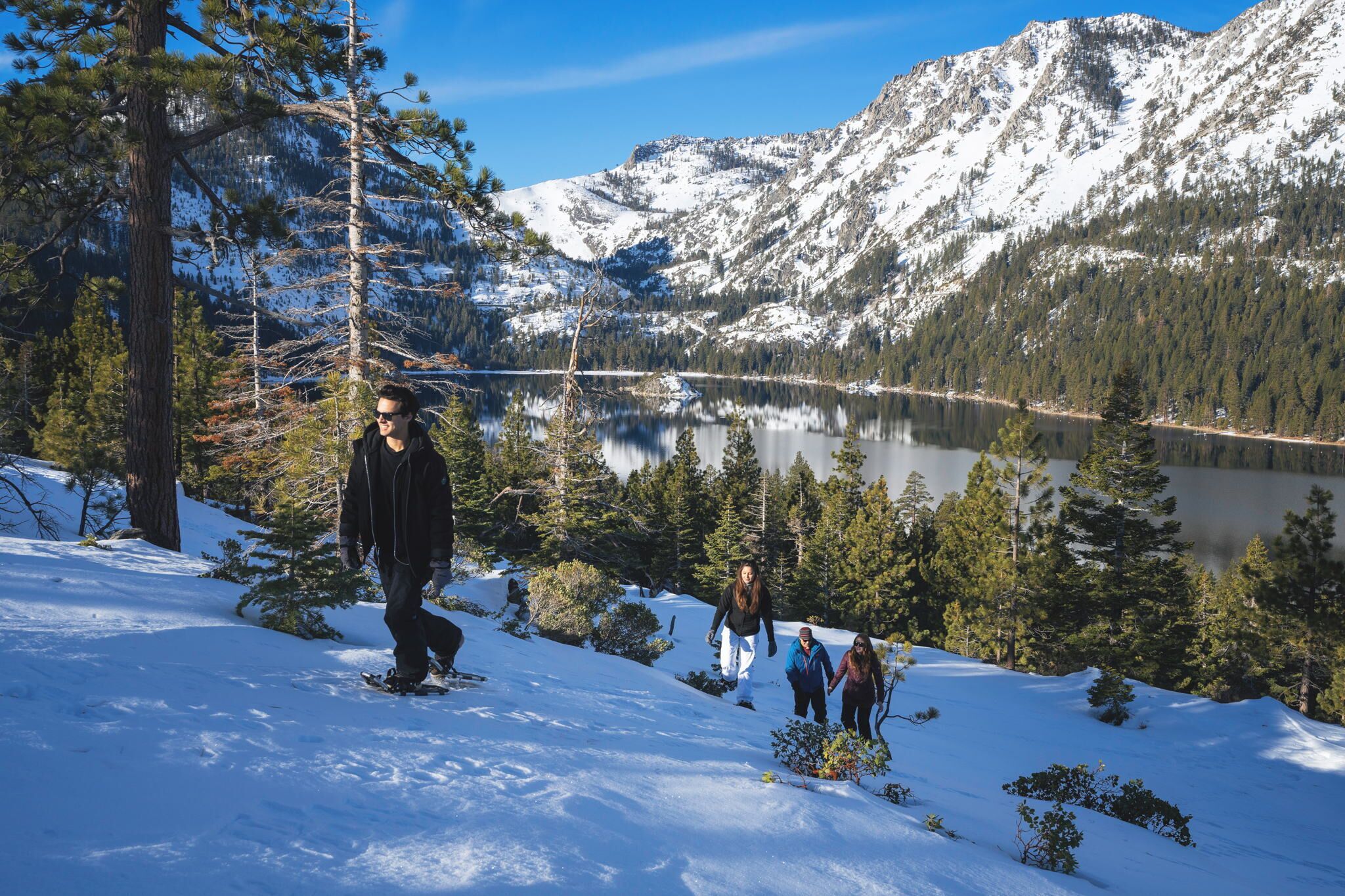 A snowy mountain landscape with a lake and trees.