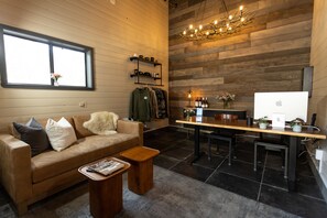 A modern living room with a sofa, coffee table, and a dining area with a kitchen counter.