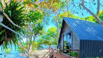 A wooden structure with a metal roof, a wooden staircase, and a sandy beach area.