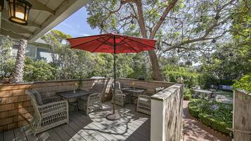 Relax and socialize in this serene outdoor space, featuring a deck with wicker furniture and a fence.