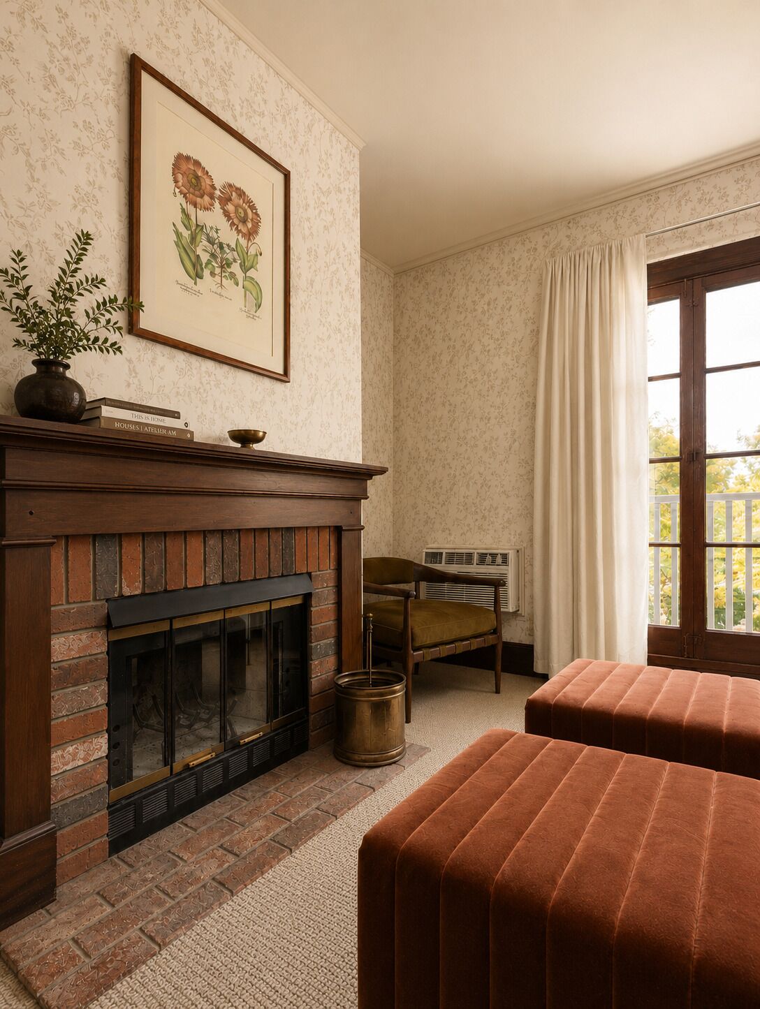 A room with a fireplace, a framed botanical print, a window with curtains, and a seating area.