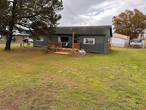 Ett litet, envåningshus med en veranda och ett garage.
