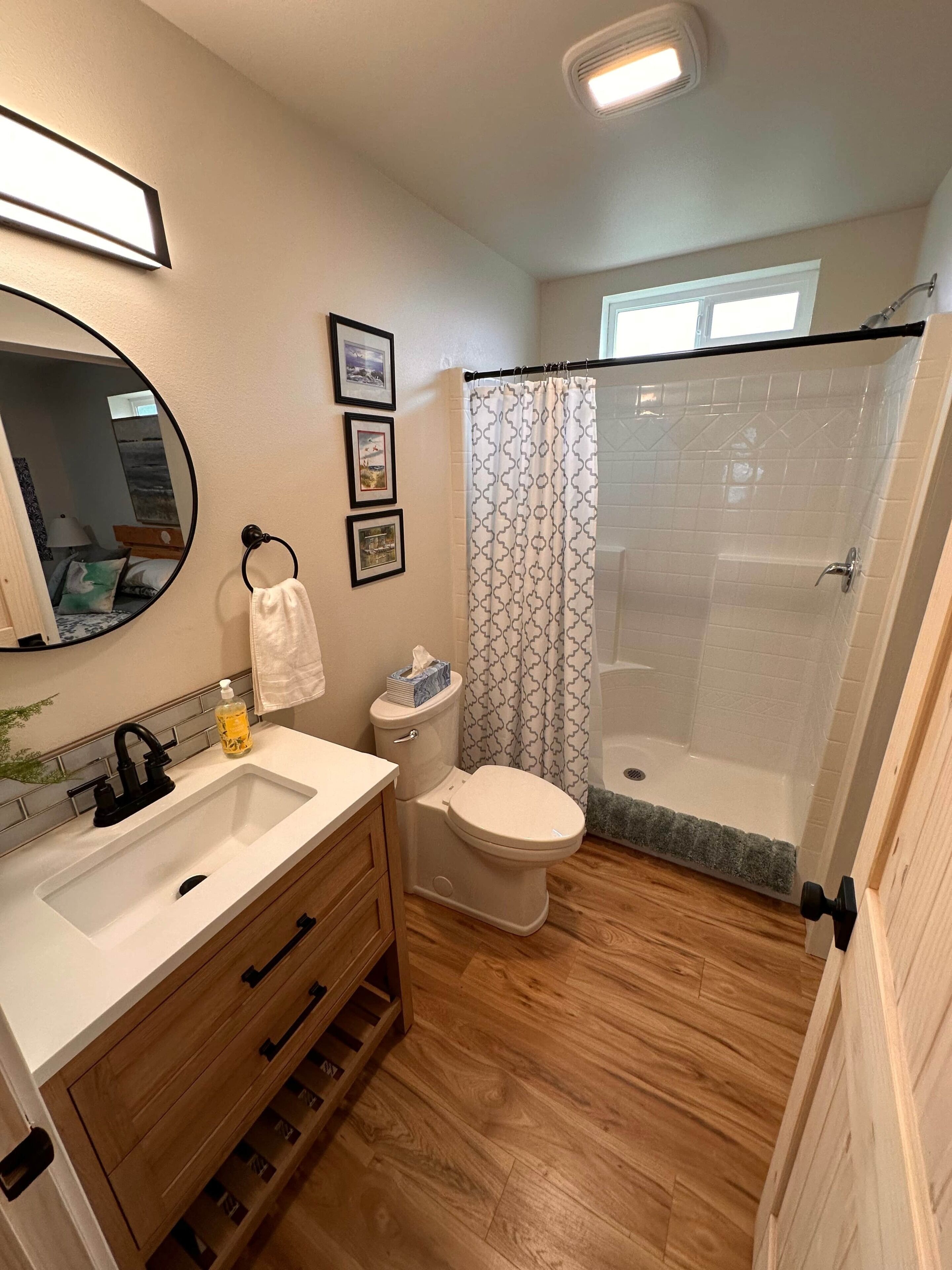 A bathroom with a toilet, sink, and shower area.