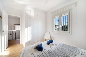 Une chambre à coucher avec un lit, une fenêtre, une porte et une vue sur l’extérieur.