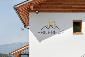 Un edificio con el logotipo de una montaña y el nombre 'EBNERHOF' en la fachada.