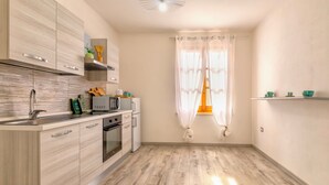 A modern kitchen with wooden cabinets, a built-in oven, and a microwave.