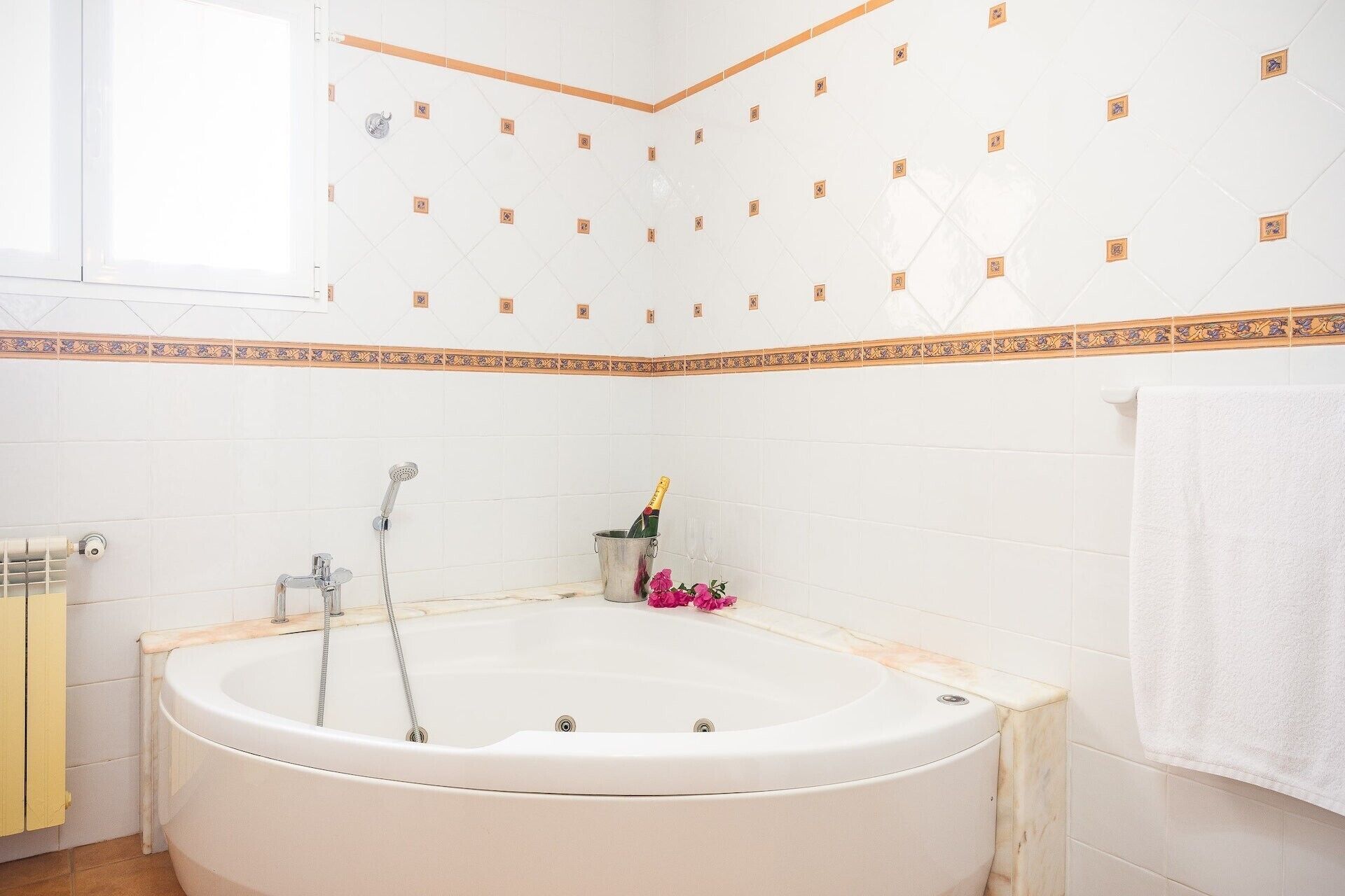 A bathroom with a large bathtub, a shower, and a toilet.