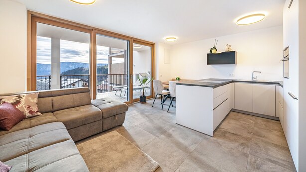 A modern apartment with a living area, kitchen, and balcony with a city view. - Apartment 'Klara' with Mountain View, Private Terrace and Wi-Fi (Mölten)