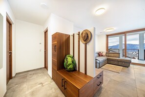 A modern living room with a sofa, a wooden bench, and a hat on the wall.