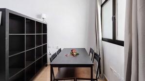 A room with a dark wooden table, six chairs, a potted plant, and a large window with curtains. - Apartment 'Noa' with Wi-Fi (San Sebastián de La Gomera)