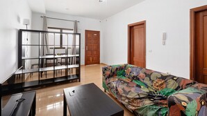 A living room with a sofa, a coffee table, a TV stand, and a ceiling fan. - Apartment 'Noa' with Wi-Fi (San Sebastián de La Gomera)