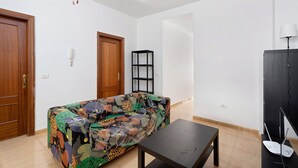A living room with a sofa, a coffee table, a TV stand, and a bookshelf. - Apartment 'Noa' with Wi-Fi (San Sebastián de La Gomera)