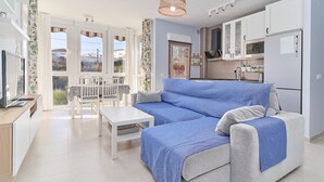 Ein modernes Wohnzimmer mit einer Couch, einem Esstisch und einer Küchenzeile.