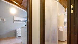 Ein Zimmer mit Dusche, einem weißen Schrank und einem Bild einer Brücke an der Wand.