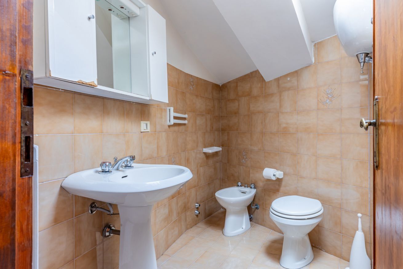 A bathroom with a pedestal sink, a bidet, and a toilet.