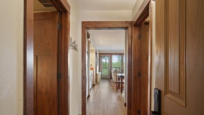 Un couloir en bois, avec un coin repas à l’arrière-plan.