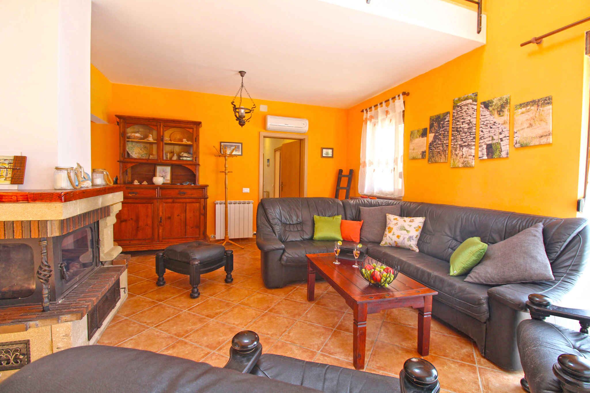 A living room with a fireplace, a sofa set, and a dining table.