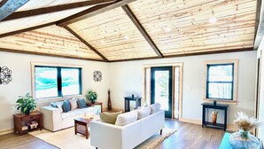 Un ampio soggiorno con soffitto alto, ampie finestre e un'accogliente area salotto.