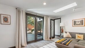 A modern living room with a sofa, a lamp, and a framed picture on the wall. - Spanish Style Highland Park Home + Free Parking (Los Angeles)