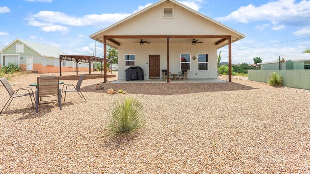 A single-story house with a covered porch, a barbecue grill, and a gravel driveway. - Experience the Wild West in Style: Unforgettable Getaway in Tombstone, Arizona!! (Tombstone)
