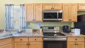 A modern kitchen with wooden cabinets, stainless steel appliances, and a granite countertop. - Experience the Wild West in Style: Unforgettable Getaway in Tombstone, Arizona!! (Tombstone)