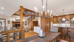 A spacious kitchen with wooden cabinets, a central island, and a chandelier. - Mountain Home in Private Gated Community (Boone)