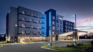 A modern hotel with multiple floors, a well-lit entrance, and a parking area. - Fairfield Inn & Suites Indianapolis Plainfield (Plainfield)