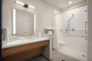 Un baño moderno con un espejo grande, dos lavamanos, ducha y bañera.