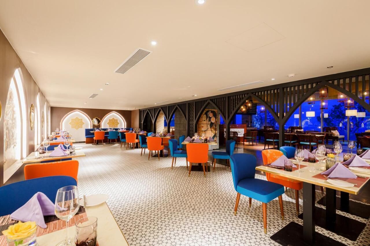 Un restaurante con varias zonas de comedor, cada una con mesas y sillas.