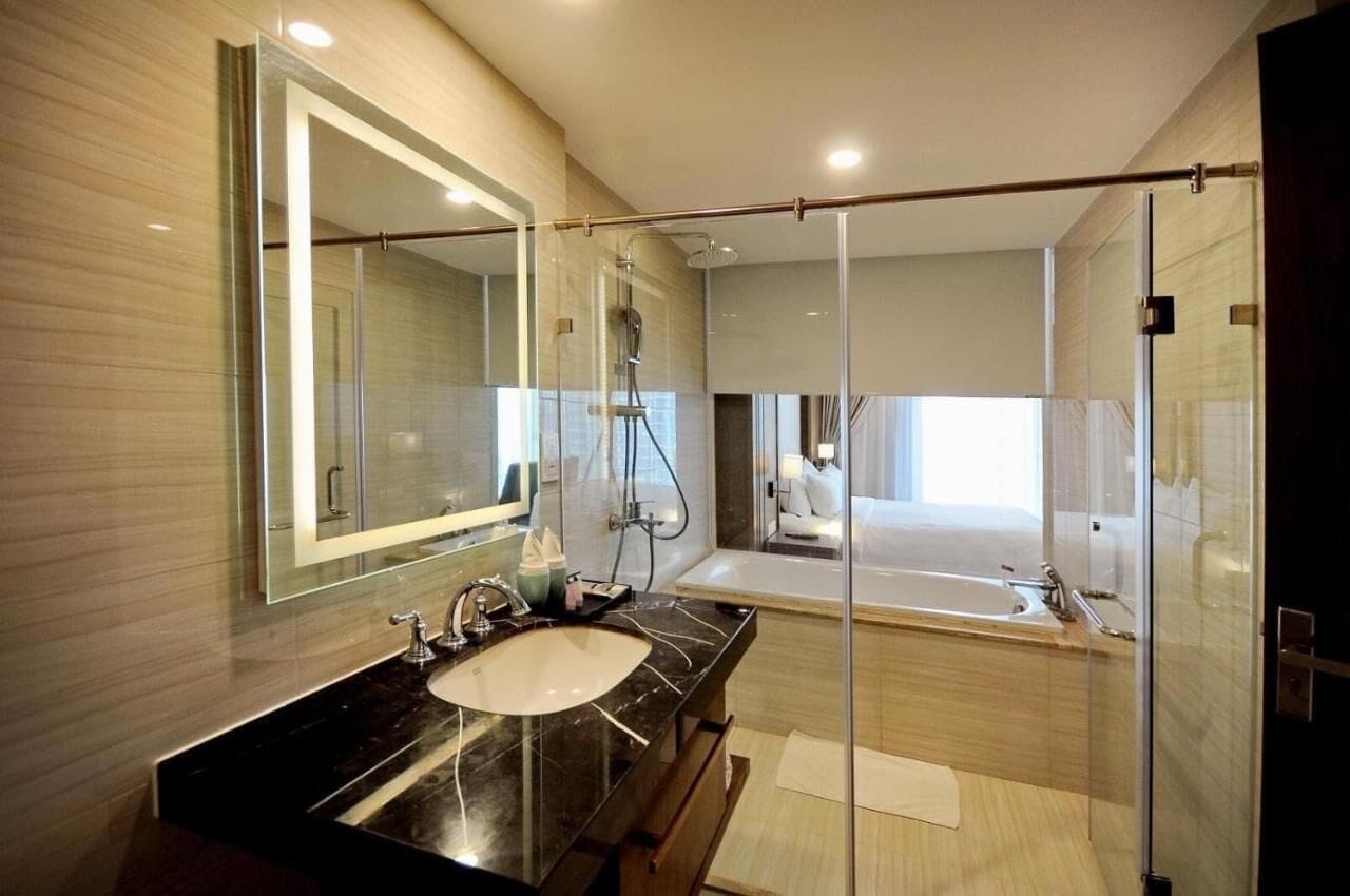 Un baño moderno con cabina de ducha de vidrio, un espejo grande y una bañera.