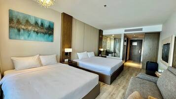 Ein Hotelzimmer mit zwei Betten, einer Couch, einem großen Gemälde und einem modernen Kronleuchter.