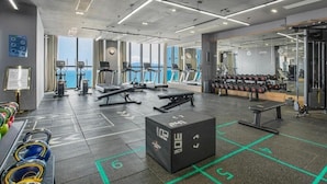 A modern gym with treadmills, weights, and a squat rack.