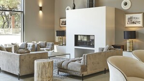 Uma sala de estar moderna com lareira, sofás e uma janela grande.