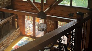 A high-ceilinged wooden cabin with large windows and a stone fireplace. - Luxury Log Cabin adjoins GSMNP . Magnificent Views , Nature Lovers Paradise ! (Townsend)