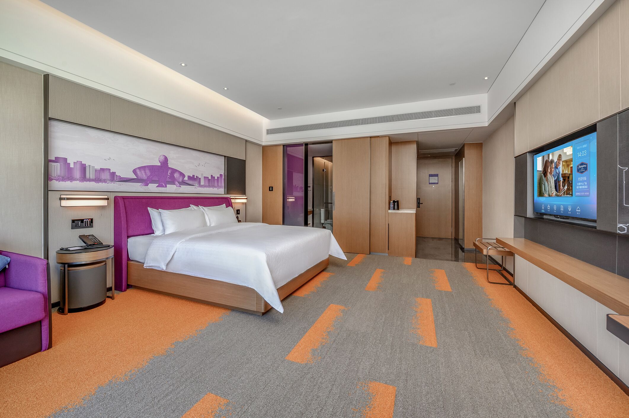Una habitación de hotel moderna con una cama grande, televisor, escritorio y un mural con vista a la ciudad.