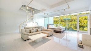A modern living room with a sofa, a coffee table, a bed, and a staircase. - Gyeongju Lineview Poolvilla (Gyeongju)