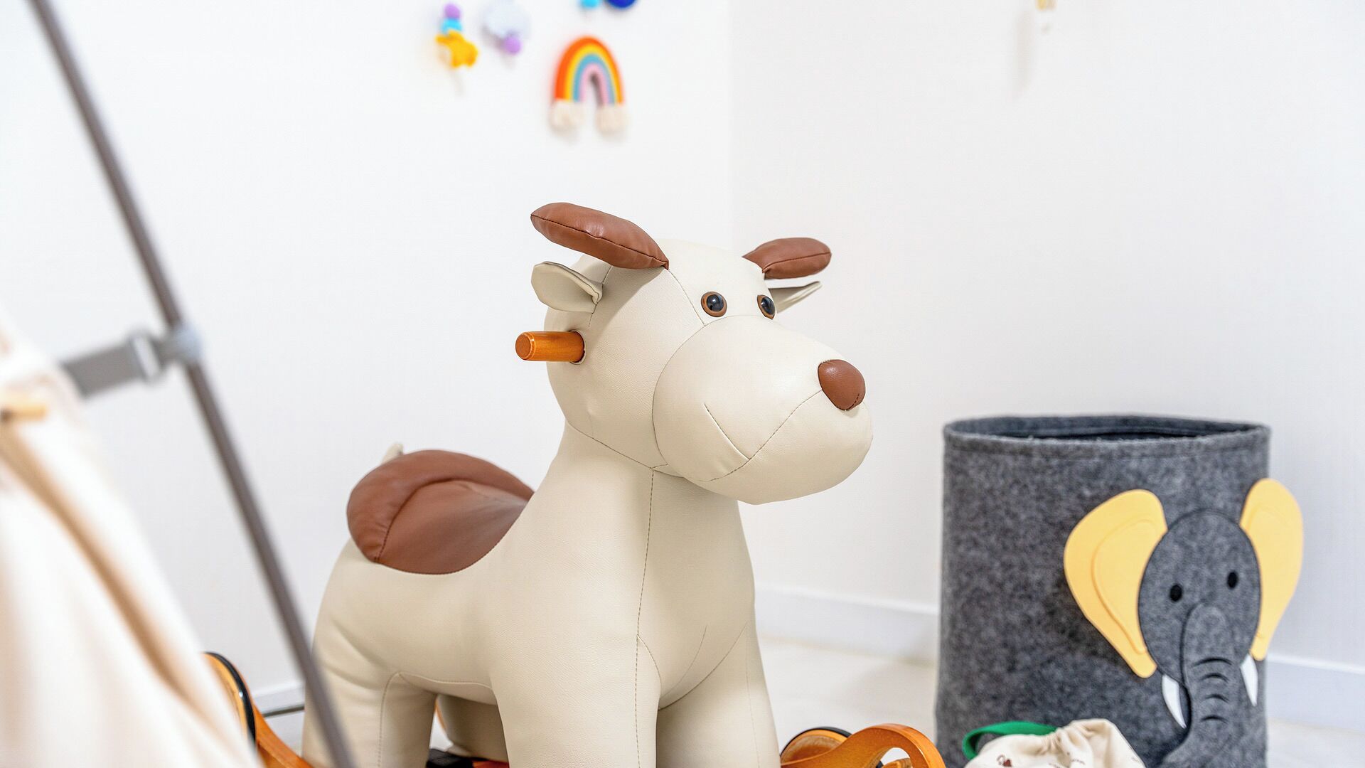 Un peluche con forma de vaca, un juguete de elefante de fieltro y un recipiente gris de fieltro.