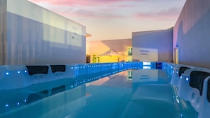 An indoor swimming pool with blue lighting, surrounded by walls and a ceiling with a sunset view. - Gyeongju Lineview Poolvilla (Gyeongju)