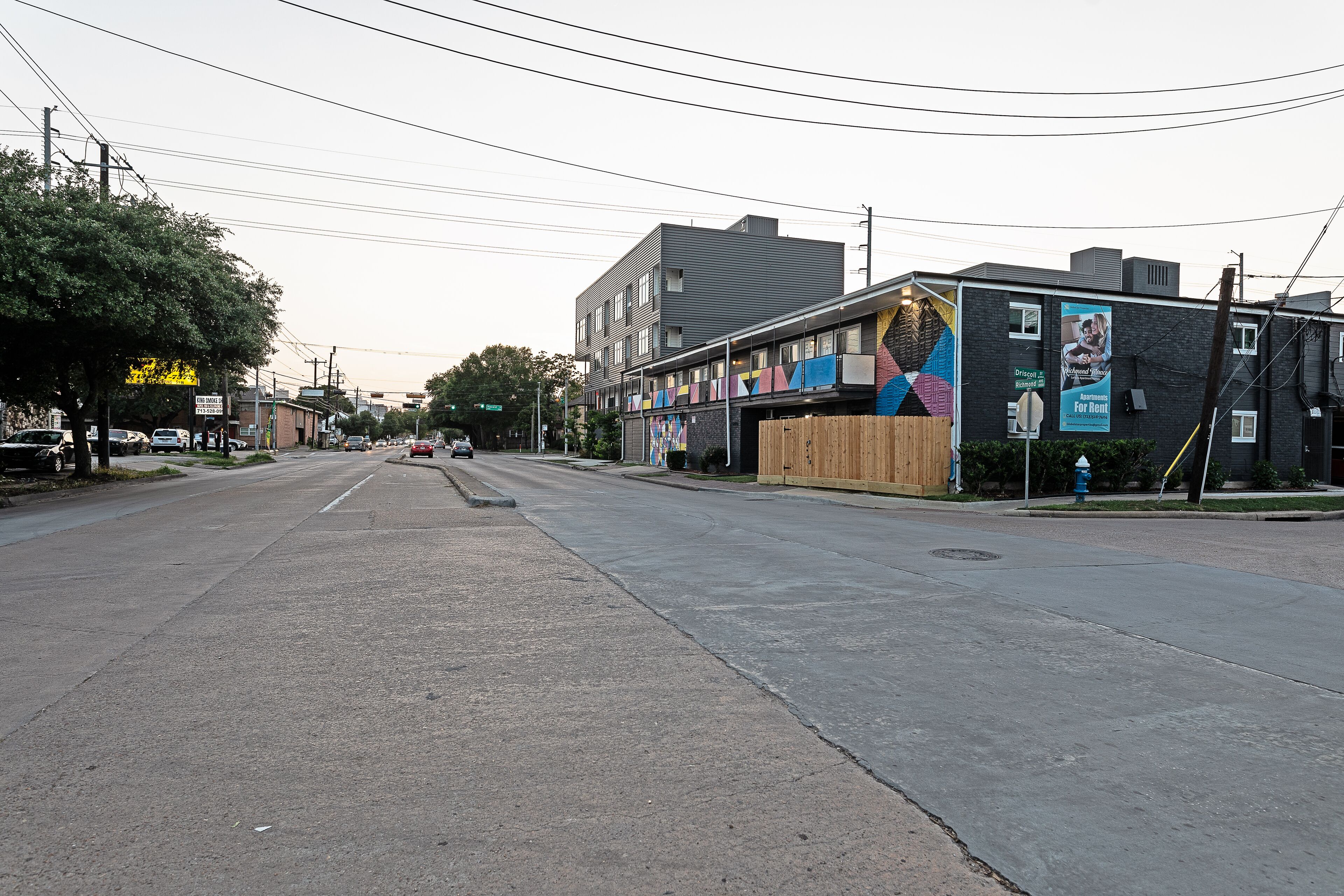 A street view with a building featuring a large mural on the side.